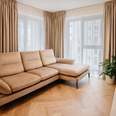 amenajare living apartament cu canapea bej și finisaje naturale